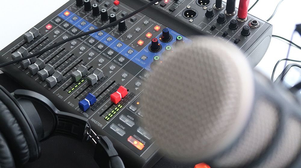 Microphone blurred with a mixer in the background
